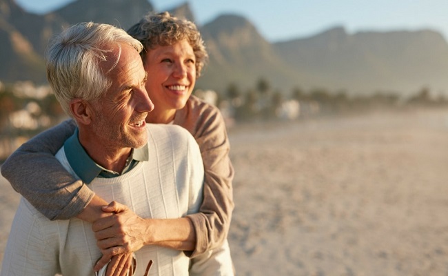 pensionati all'estero abbracciati sulla spiaggia